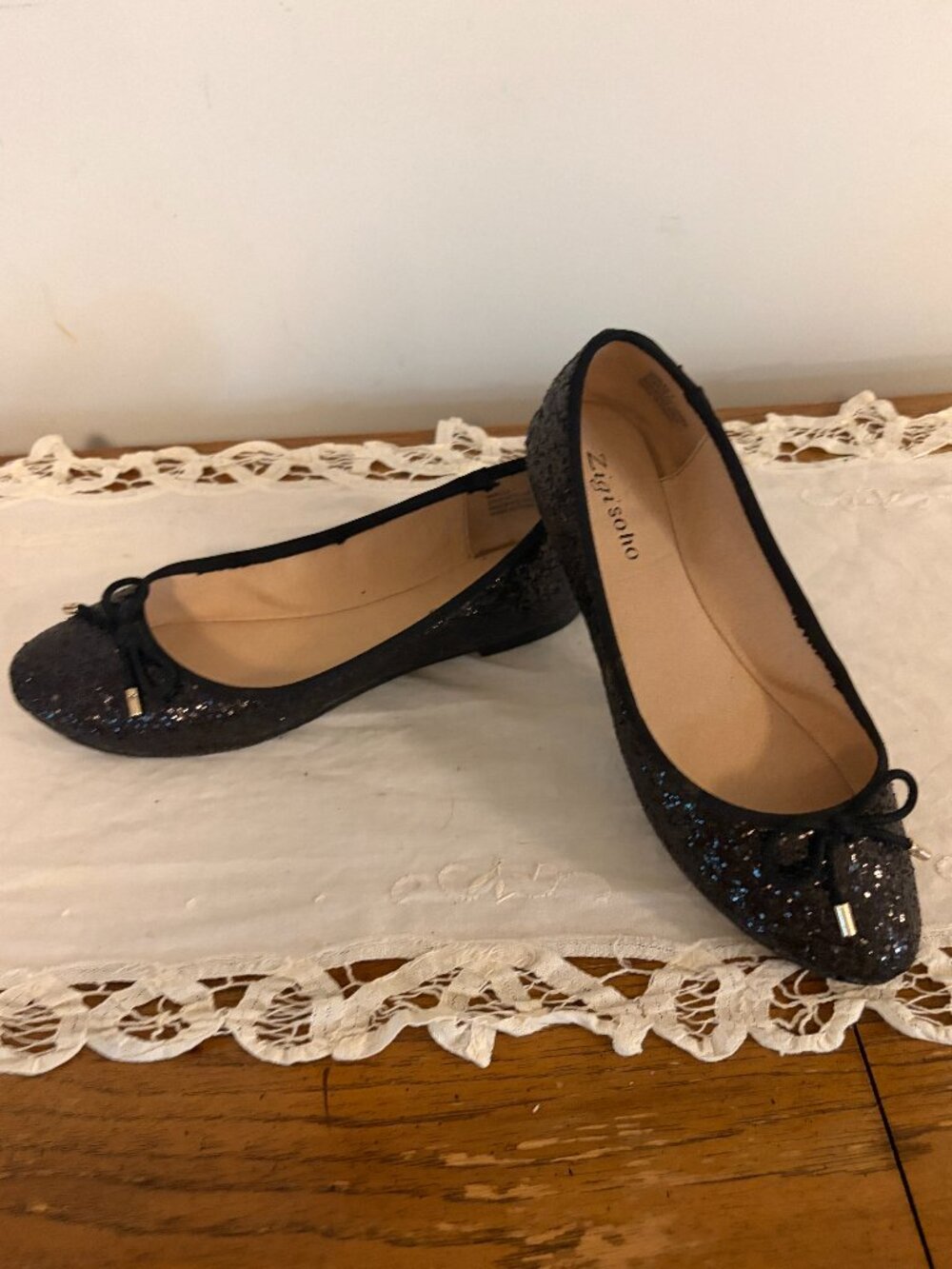 Zigisoho Women's Size 7 Synthetic Glitter Flat with Cord Bow on top. Black